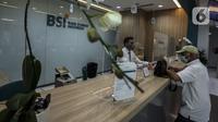 Pekerja melayani nasabah di kantor cabang Bank Syariah Indonesia, Jakarta Selasa (2/2/2021). Dirut BSI Hery Gunardi menjelaskan bahwa integrasi tiga bank syariah BUMN yakni Bank BRI Syariah, BNI Syariah, dan Bank Syariah Mandiri telah dilaksanakan sejak Maret 2020. (Liputan6.com/Johan Tallo)