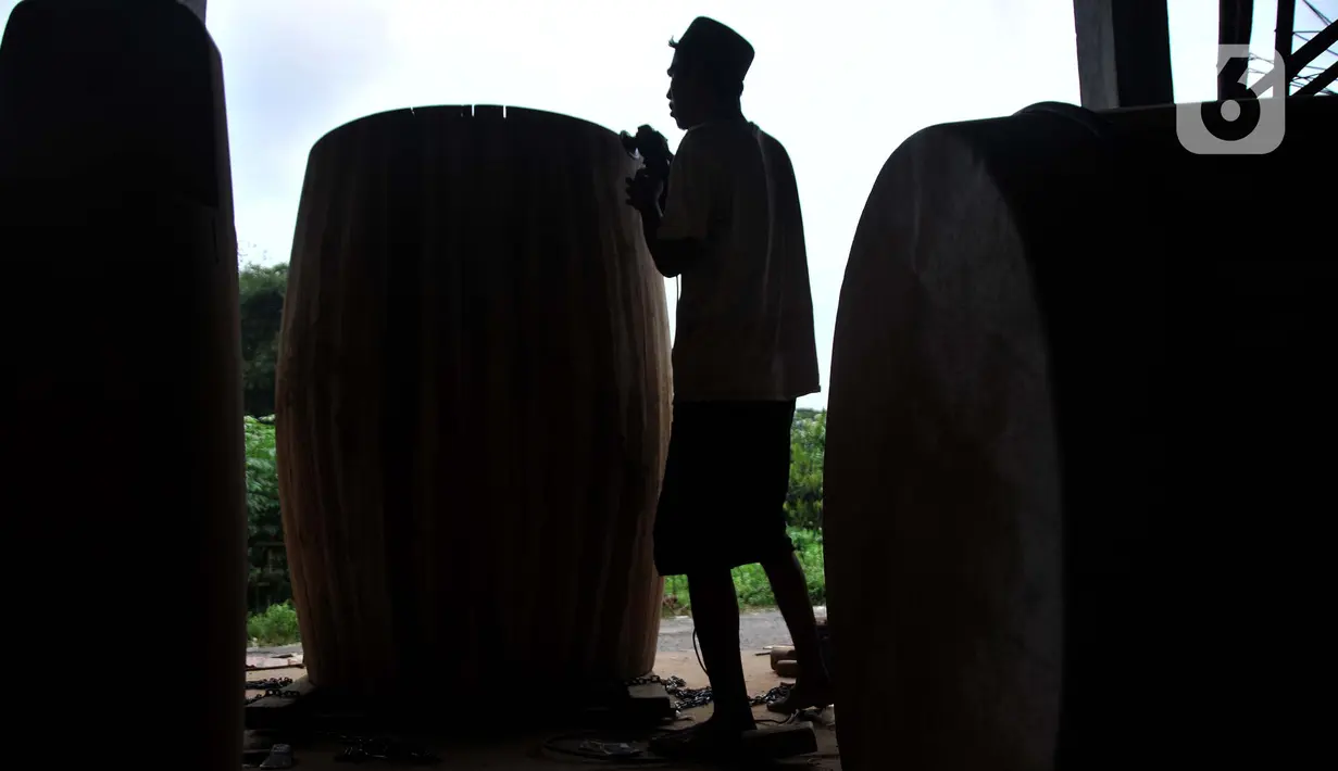 <p>Perajin menyelesaikan pembuatan beduk Al Mubarok di Desa Gumulung, Kecamatan Greged, Kabupaten Cirebon, Jawa Barat pada akhir Maret 2022 lalu. Sudah puluhan tahun Desa Gumulung terkenal sebagai sentra kerajinan beduk di Cirebon. Salah satu generasi penerus, yakni Amin Mubarok (30) mengungkapkan beduk buatannya telah tersebar di berbagai kota di Indonesia, bahkan sudah mencapai Taiwan. (merdeka.com/Iqbal S Nugroho)</p>