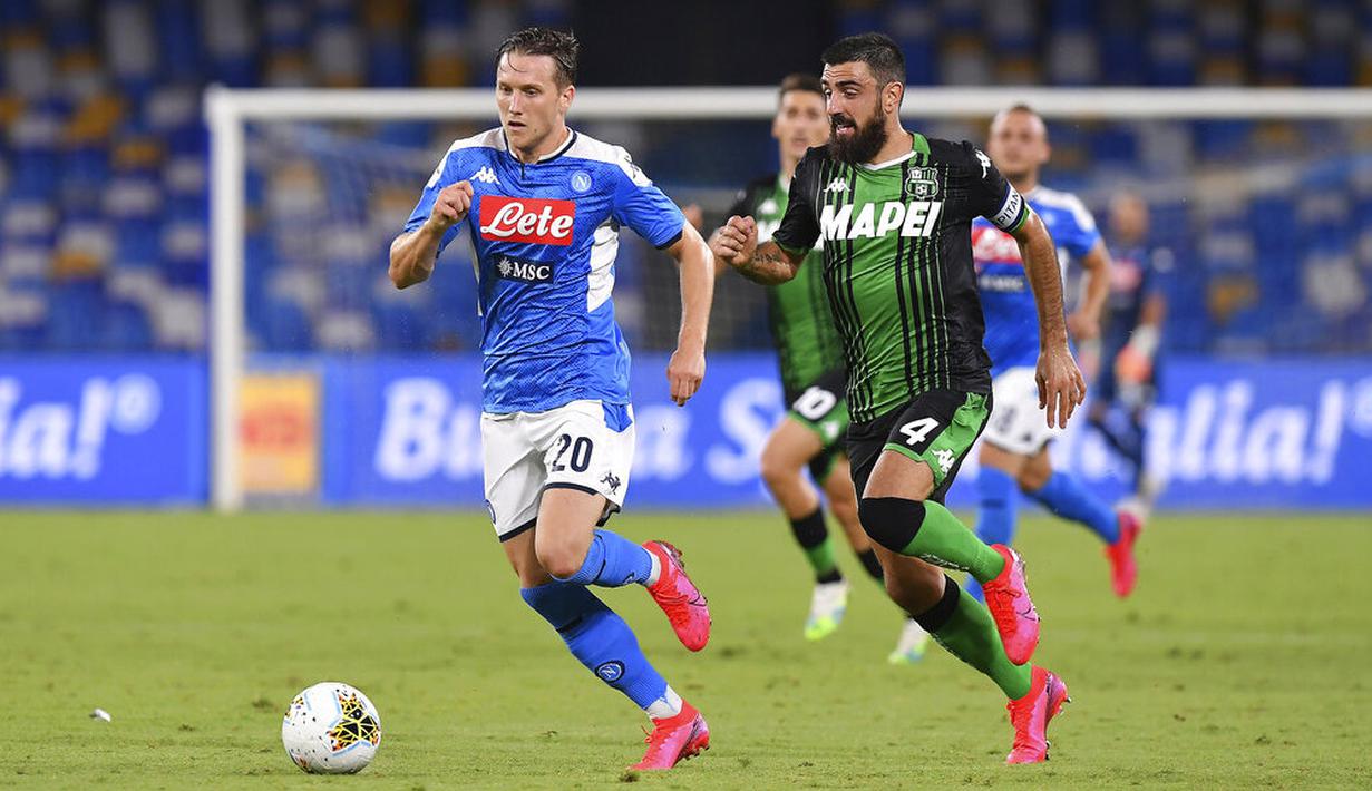 Pemain Napoli, Piotr Zielinski, berebut bola dengan pemain Sassuolo, Francesco Manganelli, pada laga Serie A di Stadion San Paolo Sabtu (25/7/2020). Napoli menang 2-0 atas Sassuolo. (Cafaro/LaPresse via AP)