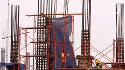 Pekerja tengah membangun gedung bertingkat di kawasan Jakarta, Rabu (5/1/2022). Gubernur DKI Jakarta Anies Baswedan membeberkan beberapa alasan merevisi  kenaikan upah minimum provinsi (UMP) 2022 pada pertengahan Desember 2021. (Liputan6.com/Angga Yuniar)