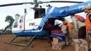 Petugas menurunkan barang dari helikopter PMI yang mendistribusikan bantuan untuk korban banjir bandang dan longsor di Desa Cileuksa, Sukajaya, Bogor, Jawa Barat, Senin (6/1/2019). PMI mengerahkan helikopter karena lokasi bencana tidak bisa dijangkau melalui jalur darat. (Liputan6.com/Tim Media JK)