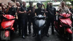 Menristekdikti Mohammad Nasir berpose di atas Motor listrik bernama Garansindo Electric Scooter ITS (GESITS) di Jakarta, Senin (7/11). GESITS adalah hasil kerjasama Garansindo dengan Institut Teknologi Sepuluh November (ITS). (Liputan6.com/Helmi Afandi)