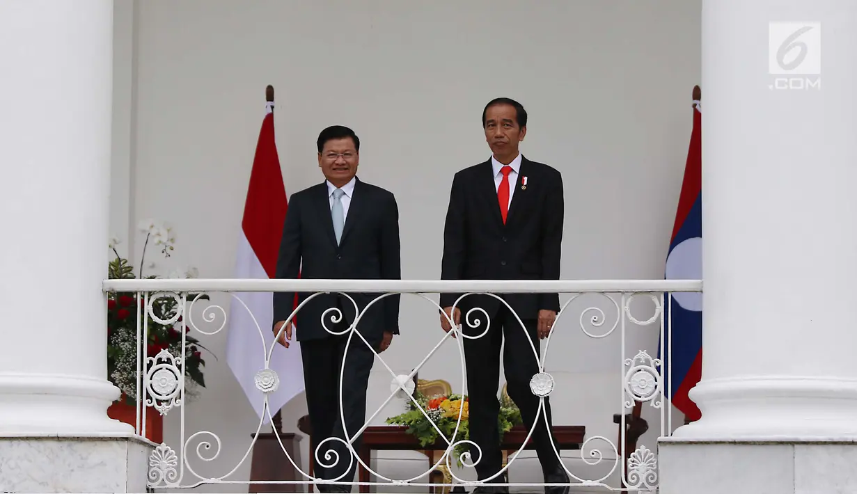 Presiden Jokowi dan PM Republik Demokratik Rakyat Laos Thongloun Sisoulith berjalan menuju beranda Istana Bogor, Kamis (12/8). Kedua kepala negara itu melakukan pertemuan bilateral, serta penandatanganan nota kesepahaman. (Liputan6.com/Angga Yuniar)