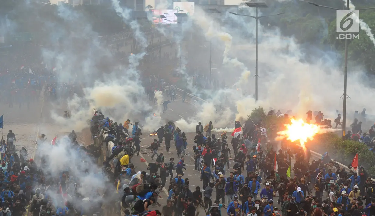 Mahasiswa berlarian saat polisi menembakkan gas air mata dalam demonstrasi menolak pengesahan RUU KUHP dan revisi UU KPK di depan Gedung DPR, Jakarta, Selasa (24/9/2019). Polisi menghalau mahasiswa yang berusaha masuk ke area Gedung DPR. (merdeka.com/Arie Basuki)