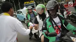 Relawan Millennial Jokowi-Amin membagikan coklat kepada pengendara roda dua dan empat di kawasan Patung Kuda, Jakarta, Kamis (18/4). Kegiatan tersebut sebagai bentuk terima kasih kepada seluruh anak bangsa yang telah ikut memberikan suaranya di TPS. (Liputan6.com/Faizal Fanani)