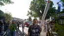 Warga membawa benda berbentuk lintingan ganja saat mengikuti Global Cannabis March di Wina, Austria, (6/5). Global Cannabis March juga menyatakan menentang perdagangan narkoba. (AFP Photo/Joe Klamar)