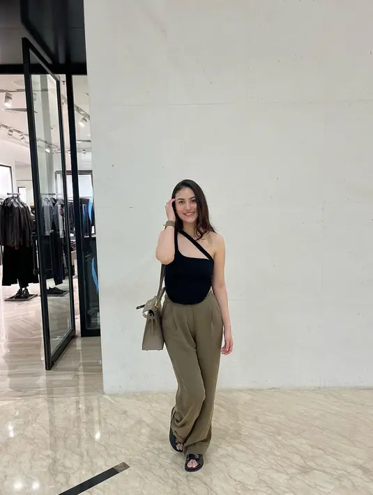 Seperti potret ini, Marcella tampil kece memadukan cut out tank top dengan loose pants warna army.