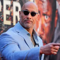 Aktor AS Dwayne Johnson tiba menghadiri pemutaran perdana film "Skyscraper" di New York City, AS (10/7). Dwayne Johnson tampil keren dengan kaca mata hitam dan setelan kemeja berwarna abu-abu. (AFP Photo/Kena Betancur)