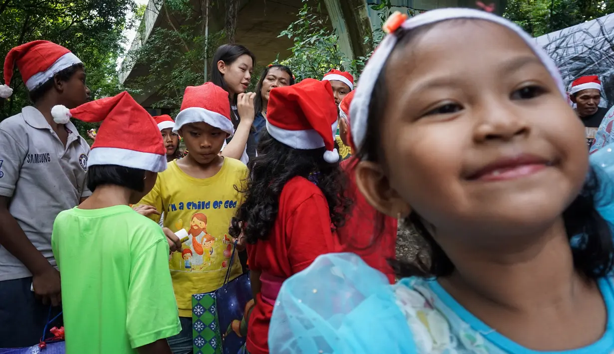 Euclia Purnama kemudian mulai membagikan bantuan untuk para anak-anak. Terlihat keceriaan di wajah mereka. (Bola.com/Bagaskara Lazuardi)