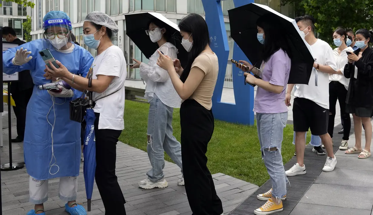Para pekerja yang mengenakan masker berbaris untuk tes COVID-19 di Beijing, China, 12 Juli 2022. Beijing telah membatalkan rencana untuk mengizinkan hanya orang yang divaksinasi yang memasuki ruang publik. (AP Photo/Ng Han Guan)