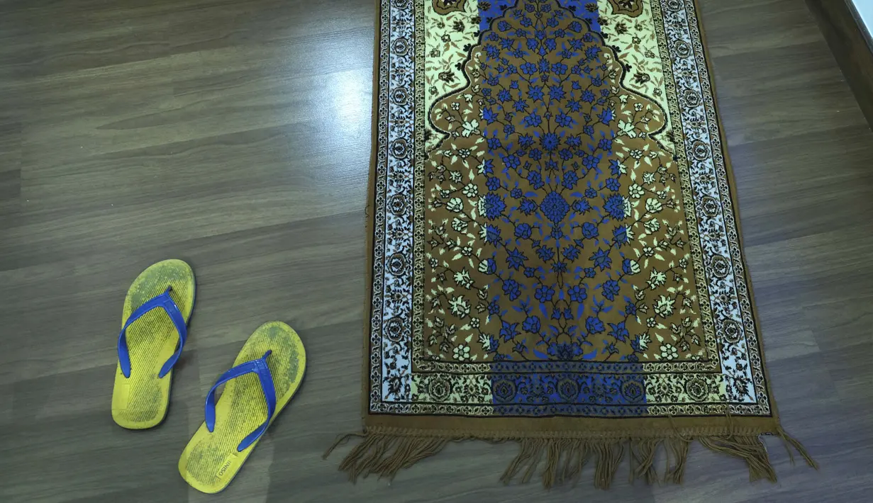 Sepasang sandal ada dekat sajadah di kamar hotel tempat fotografer Associated Press Rafiq Maqbool dikarantina, Mumbai, India, 24 April 2020. Berdoa membantunya merasa lebih baik. (AP Photo/Rafiq Maqbool)