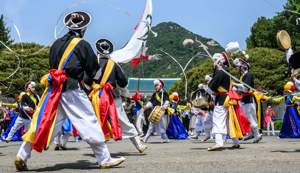 Penampil menari dekat Kompleks Blue House sehari setelah dibuka untuk umum menyusul janji kampanye Presiden Korea Selatan Yoon Suk-yeol di Seoul, Korea Selatan, 11 Mei 2022. (ANTHONY WALLACE/AFP)