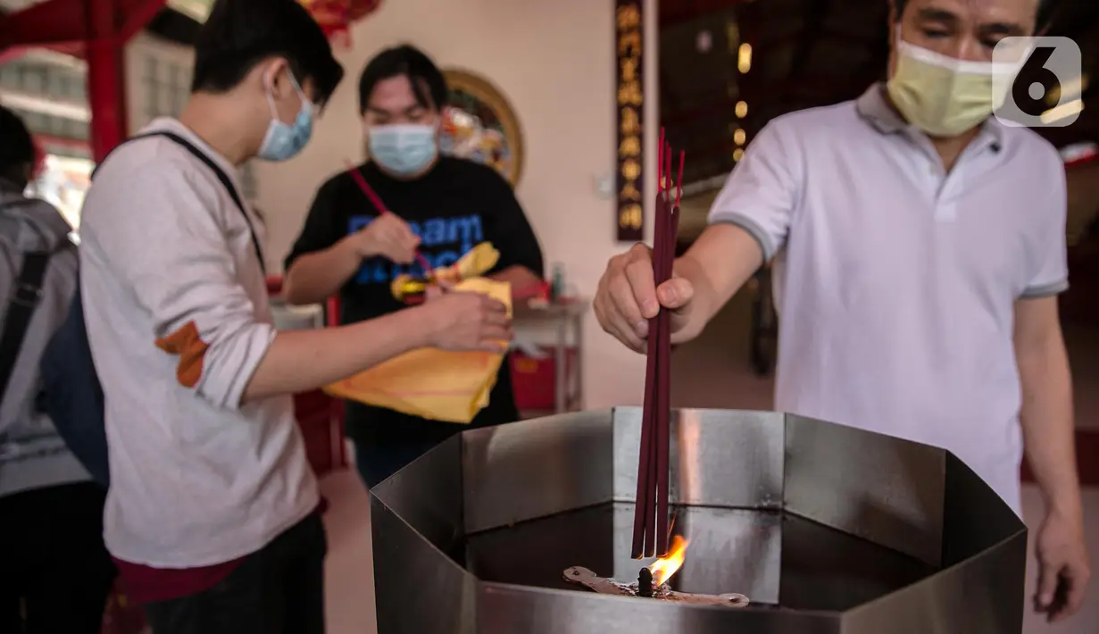 Warga menyalakan dupa untuk bersembahyang di Vihara Dharma Bakti yang baru di kawasan Glodok, Jakarta, (1/2/2021). Warga keturunan Tionghoa tetap dapat berdoa di waktu-waktu yang telah ditentukan dan akan dibatasi jumlah pengunjungya. (Liputan6.com/Faizal Fanani)