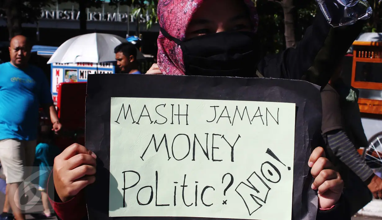 Mahasiswa yang tergabung dalam TPPJ KAMMI membawa poster saat aksi damai disela kegiatan Car Free Day di Jakarta, Minggu (9/4). Aksi itu sebagai bentuk imbauan agar masyarakat tidak terlibat politik uang dalam Pilkada DKI 2017. (Liputan6.com/Angga Yuniar)