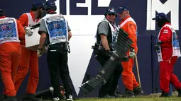 Para marshal mengumpulkan puing dari mobil balap yang hancur akibat kecelakaan saat pertarungan di lap 17 F1 Grand Prix Australia di Melbourne, Minggu (20/3). Balap Grand Prix Australia sempat dihentikan akibat kecelakaan tersebut. (REUTERS/Joe Castro)