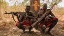 Penggembala dari suku Dinka Makal Maker (kanan) dan Achiek Butich memegang senjata untuk menjaga hewan ternak mereka di Mingkaman, Lakes State, Sudan Selatan, Minggu (4/3). (Stefanie GLINSKI/AFP)