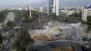 Polisi dan demonstran bentrok dalam protes anti-pemerintah di Santiago, Chile (4/10/2019). Ribuan warga Chile kembali turun ke jalan memprotes layanan sosial yang lebih baik. (AP Photo/Esteban Felix)