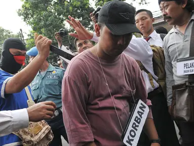 Tersangka JL melakukan reka ulang saat hendak membunuh aktivis Jopi Peranginangin, Kemang, Jakarta, Kamis (11/06/2015). Proses rekonstruksi tersebut terdiri dari 31 reka adegan yang diperankan oleh tersangka dan saksi-saksi. (Liputan6.com/Andrian M Tunay)