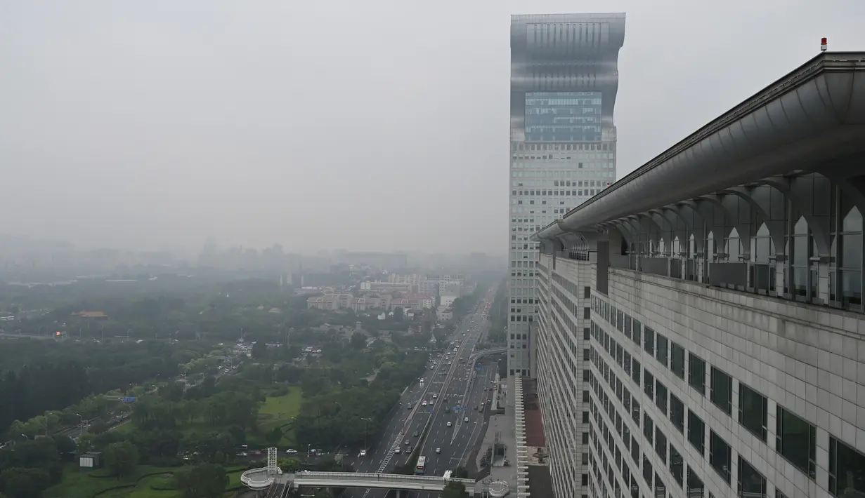 Gedung pencakar langit Pangu Plaza yang mendominasi daerah di seberang Stadion Olimpiade Bird's Nest, pusat kota Beijing, Selasa (20/7/2019). Bangunan 40 lantai hasil sitaan terkait kasus korupsi itu terjual dalam lelang online dengan harga 734 juta USD atau sekitar Rp10,5 triliun. (GREG BAKER/AFP)