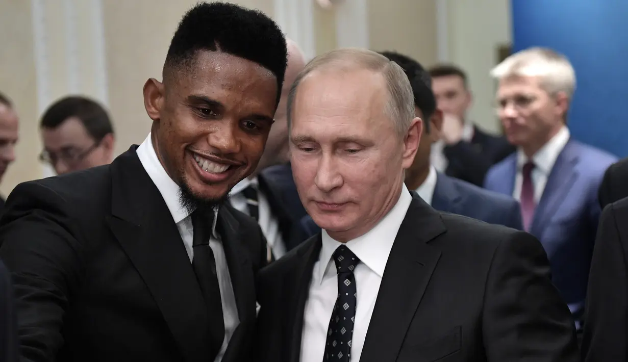 Presiden Rusia Vladimir Putin (kanan) berfoto bersama bintang sepak bola Kamerun, Samuel Eto'o saat menghadiri undian Piala Dunia 2018 di Moskow, Rusia (1/12). (Alexei Nikolsky, Sputnik, Kremlin Pool Photo via AP)