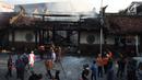 Petugas pemadam kebakaran dan warga berkumpul di lokasi kebakaran yang melanda kompleks Kelenteng Tay Kak Sie di Gang Lombok, Semarang, Kamis (21/3). Dilaporkan satu orang tewas dalam insiden kebakaran ini. (Liputan6.com/Gholib)