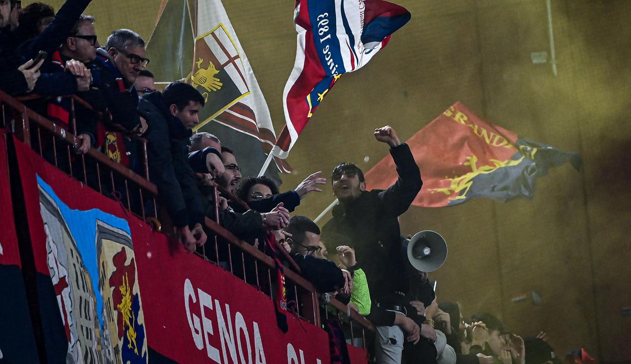 Para suporter Genoa menyanyikan lagu untuk mendukung timnya saat laga lanjutan Liga Italia 2023/2024 melawan Inter Milan di Stadion Luigi Ferraris, Genoa, Italia, Sabtu (30/12/2023) dini hari WIB. (AFP/Piero Cruciatti)