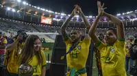 Bek Brasil, Dani Alves, bersama putranya merayakan gelar juara Copa America 2019 setelah mengalahkan Peru pada laga final di Stadion Maracana, Rio de Janeiro, Minggu (7/7). Brasil menang 3-1 atas Peru. (AFP/Carl De Souza)