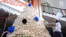 Karyawan menghiasi pohon Natal yang terbuat dari susunan donat di lobby hotel Dafam Semarang, Rabu (12/12). Pohon Natal setinggi 3 meter untuk menyambut Natal tersebut terdapat 2000 buah kue donat. (Liputan6.com/Gholib)