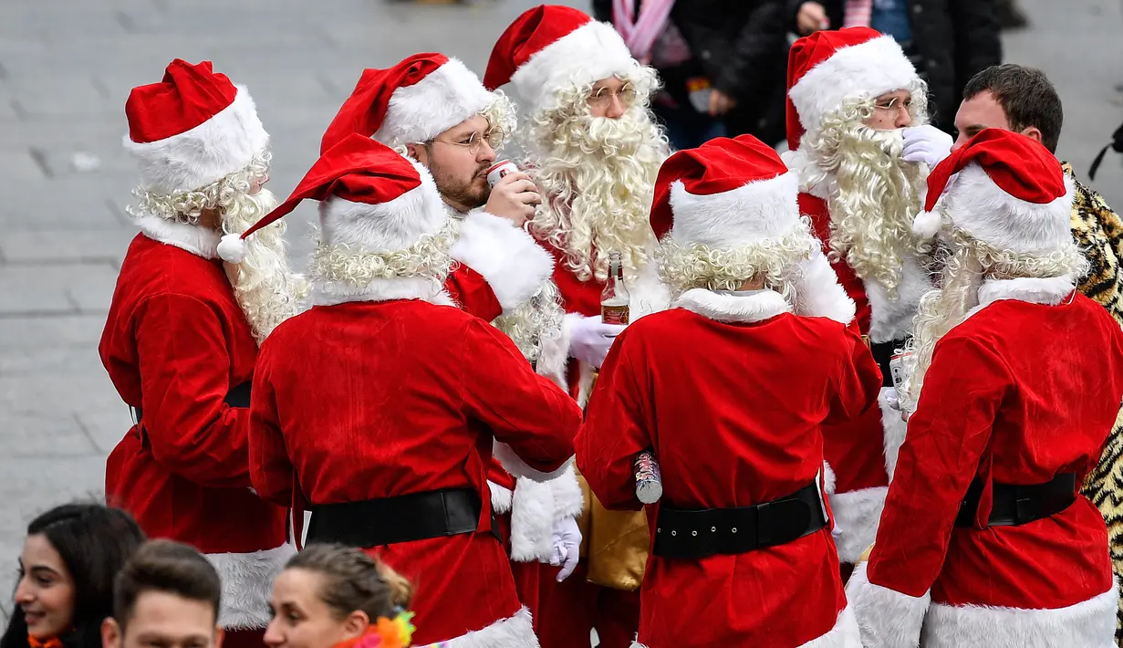 Sekelompok pria dengan kostum Santa Claus tiba di stasiun kereta api saat orang-orang menyambut dimulainya musim karnaval di jalan-jalan Kota Cologne, Jerman, Senin (11/11/2019). Kostum berbagai warna dan bentuk menambah suasana meriah di jalan-jalan dan tempat-tempat umum (AP Photo/Martin Meissner)