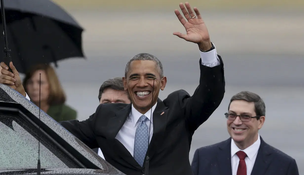 Presiden AS, Barack Obama berdiri di depan Menlu Kuba, Bruno Rodriguez ketika melambaikan tangan sebelum memasuki sebuah mobil limusin lapis baja hitam setibanya di Bandara Internasional Havana, Minggu (20/3). (REUTERS/stringer)
