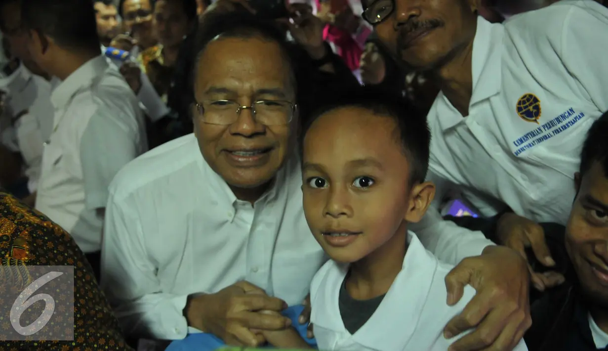 Menko Kemaritiman Rizal Ramli berpose bersama seorang anak saat meninjau keberangkatan peserta mudik gratis sepeda motor dengan kereta api di Stasiun Senen, Jakarta, Rabu (29/6). (Liputan6.com/Gempur M Surya)