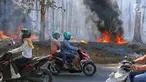 Pengendara melintas saat kobaran api membakar hutan jati di Kawasan Mijen Semarang, Sabtu (21/9/2019). Musim kemarau yang panjang dan kondisi yang kering mempermudah api menyebar di kawasan tersebut. (Liputan6.com/Gholib)
