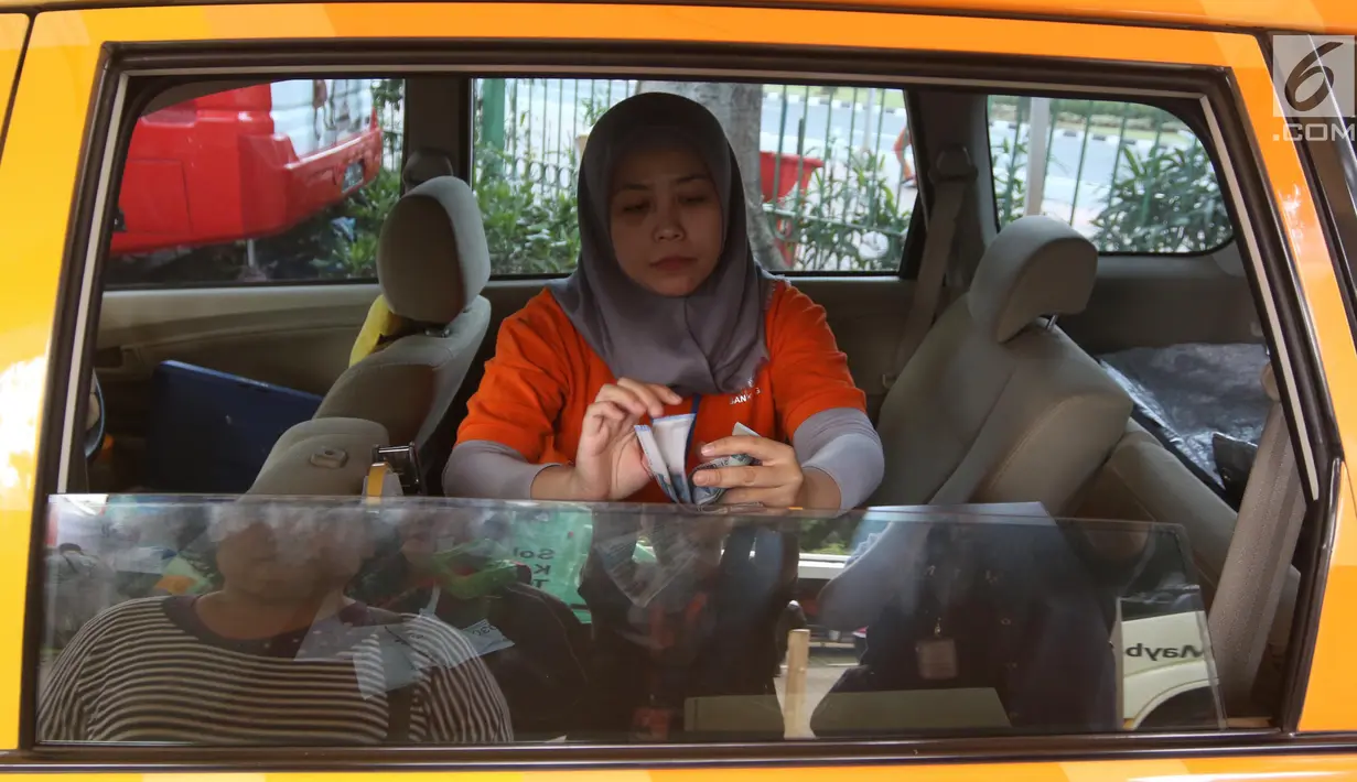 Petugas menghitung uang pecahan saat kegiatan penukaran di Lapangan IRTI Monas, Jakarta, Rabu (23/5). Masyarakat akan dilayani secara langsung dengan menggunakan stand mobil dari 14 bank baik swasta maupun bank BUMN. (Liputan6.com/Arya Manggala)