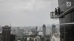 Pekerja tanpa helm keselamatan beraktivitas di gedung bertingkat di Jakarta, Rabu (15/11). Banyak kejadian kecelakaan kerja di ketinggian disebabkan karena minimnya pengetahuan dasar mengenai keselamatan kerja di ketinggian. (Liputan6.com/Faizal Fanani)