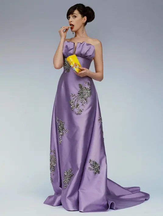 Anne Hathaway tampil luar biasa dengan gaun berwarna ungu. Off-the-shoulder long dress ini memiliki detail payet silver di seluruh bagian gaun dan bagian top yang menggembung. Foto: Instagram.