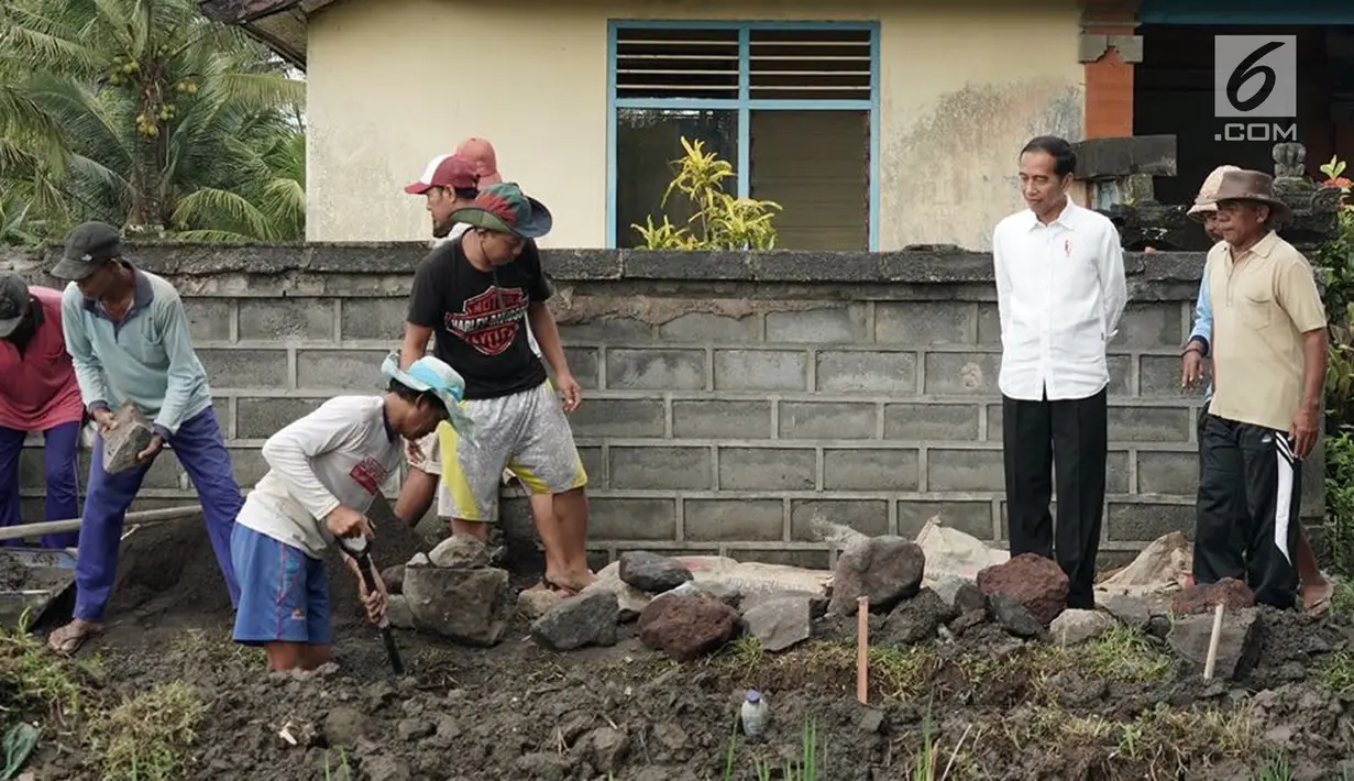 Presiden Joko Widodo atau Jokowi  meninjau pelaksanaan padat karya di Desa Kukuh, Kecamatan Marga, Tabanan, Bali, Jumat (23/2). Sebanyak 25 warga terlibat dalam pembangunan jalan produksi sepanjang 592 meter tersebut. (Liputan6.com/Pool/Biro Pers Setpres)