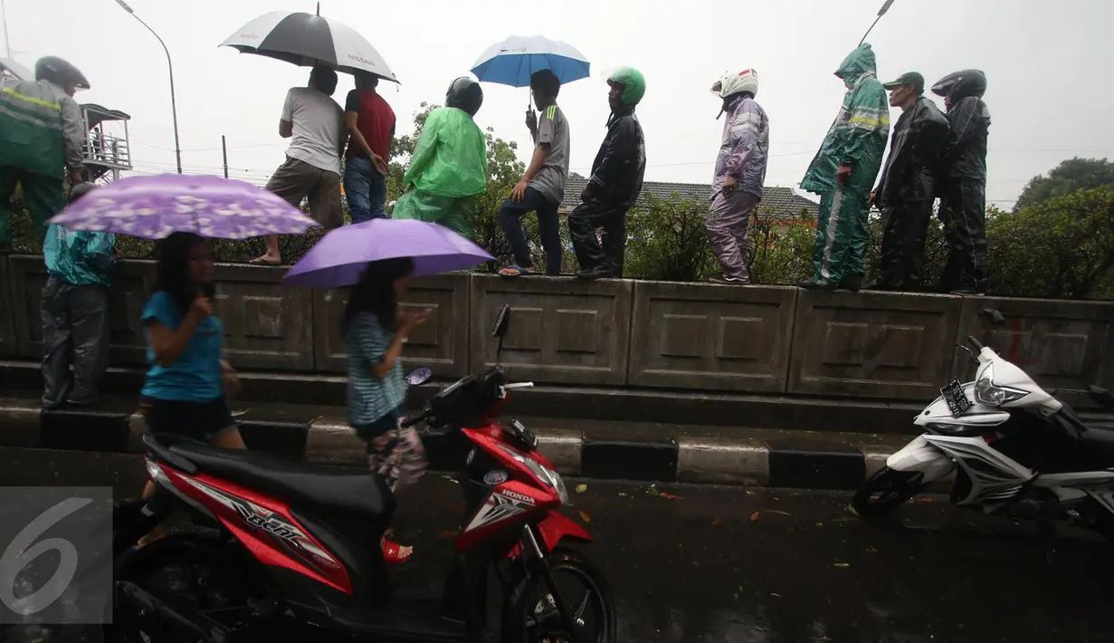 Warga menonton Jembatan Penyeberangan Orang (JPO) yang roboh akibat hujan deras dan angin kencang di Jalan Raya Pasar Minggu, Jakarta Selatan, Sabtu (24/09). Petugas masih memotong bagian JPO tersebut. (Liputan6.com/Immanuel Antonius)