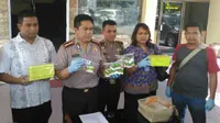 Kapolresta Pekanbaru Kombes Toni Hermawan memperlihatkan barang bukti serum palsu yang disita dari salah satu apotik di Pekanbaru. (Liputan6.com/M Syukur)