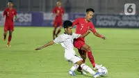 Pemain Timnas Indonesia U-19, Beckham Putra Nugraha (kanan) berebut bola dengan pemain Timor Leste pada laga kualifikasi Grup K Piala AFC U-19 2020 di Stadion Madya Gelora Bung Karno, Jakarta, Rabu (6/11/2019). Indonesia unggul 3-1. (Liputan6.com/Helmi Fithriansyah)