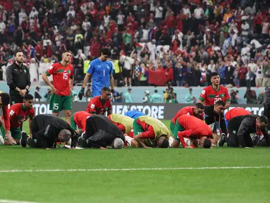 Para pemain Maroko tetap bersujud syukur usai pertandingan melawan Prancis pada semifinal Piala Dunia 2022 di Stadion Al-Bayt di Al Khor, Doha, Kamis (15/12/2022). Maroko kalah dari Prancis 2-0 dan gagal melaju ke final Piala Dunia 2022. (AFP/Karim Jaafar)