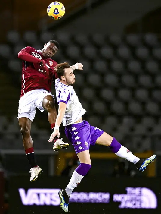 Pemain Torino Singo Wilfried (kiri) berebut bola dengan pemain Fiorentina Gaetano Castrovilli pada pertandingan Liga Italia di Olympic Stadium, Turin, Italia, Jumat (29/1/2021). Bermain dengan sembilan pemain, Fiorentina berhasil menahan imbang Torino 1-1. (Fabio Ferrari/LaPresse via AP)