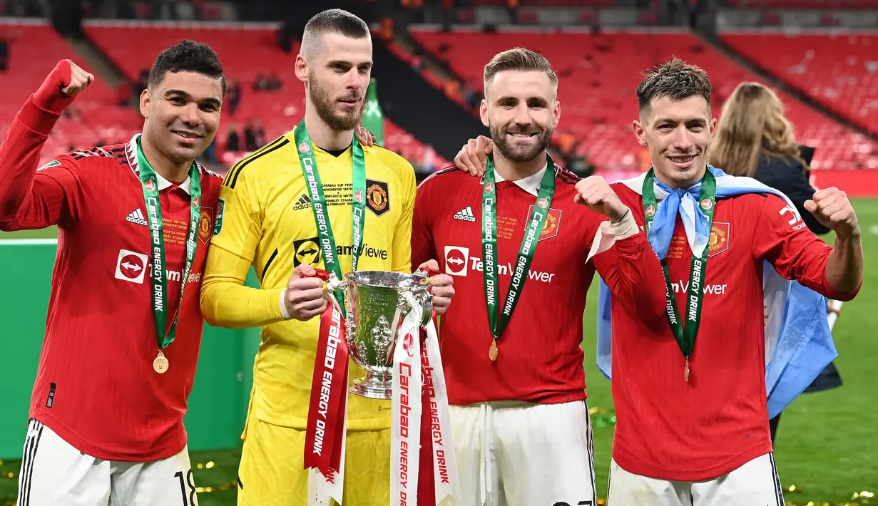 Pemain Manchester United (ki-ka), Casemiro, David De Gea, Luke Shaw, dan Lisandro Martinez berpose bersama trofi Carabao Cup 2023 setelah mengalahkan Newcastle United di Wembley Stadium, Minggu (26/2/2023) waktu setempat. (AFP/Glyn Kirk)