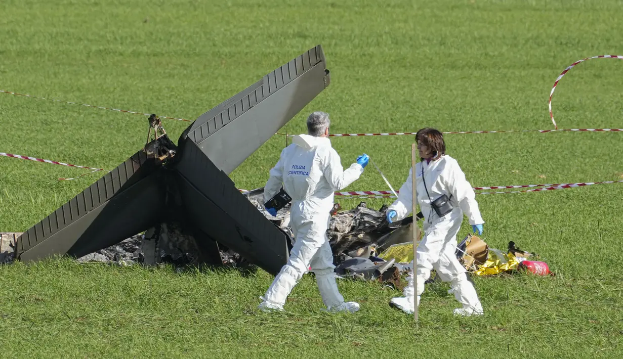 Polisi forensik memeriksa sisa-sisa yang terbakar  salah satu dari dua pesawat U-208 Angkatan Udara Italia yang jatuh di Guidonia, di pinggiran Roma, Selasa (7/3/2023).  Angkatan Udara Italia (ItAF) mengatakan dalam pernyataan resmi bahwa kedua pilot tewas, tetapi tidak ada korban lain yang dilaporkan di darat. (AP Photo/Andrew Medichini)