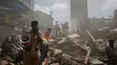 Petugas keamanan dan penyelamat mencari korban yang tertimbun puing reruntuhan bangunan di Mumbai, India (31/8). (AP Photo / Rafiq Maqbool)