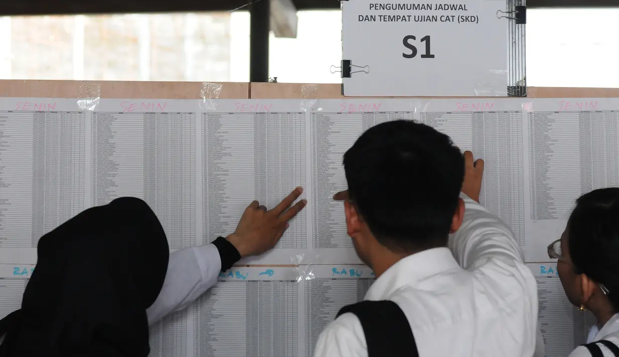 Peserta tes seleksi CPNS Kemenkumham mengecek no pendaftaran di gedung BKN, Jakarta, Senin (11/9). Pada 2017, tercatat 1.116.138 pelamar CPNS mendaftar di lingkungan Kemenkumham. (Liputan6.com/Helmi Fithriansyah)