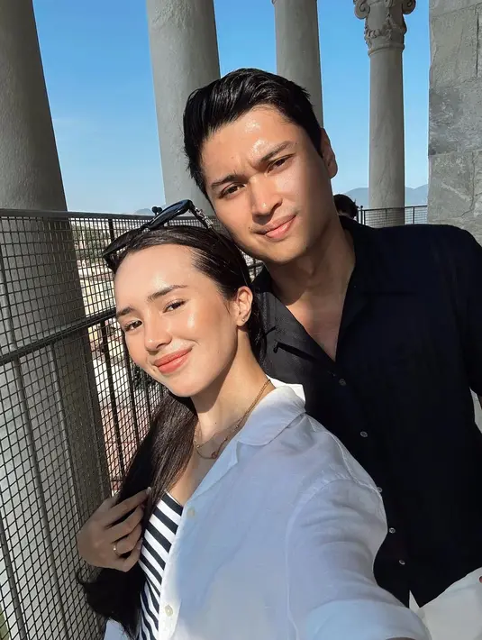 Beby Tsabina dan Rizki pilih outfit hitam putih sebagai OOTD couple saat bulan madu. Beby padukan stripe top dan kemeja putih sedangkan Rizki lebih simple dengan kemeja hitam [@bebytsabina]
