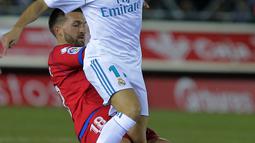 Aksi pemain Real Madrid, Lucas Vazquez (kanan) melewati adangan pemain Numancia, Grego pada laga Copa Del Rey di Nuevo Estadio Los Pajaritos stadium, Soria, (4/1/2018). Madrid menang 3-0. (AFP/Cesar Manso)