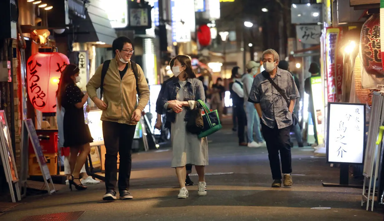 Orang-orang berjalan di sebuah jalan di Tokyo, Jepang, 4 Oktober 2021. Warga kembali beraktivitas setelah berakhirnya status pembatasan darurat virus corona COVID-19 di Jepang. (AP Photo/Koji Sasahara)