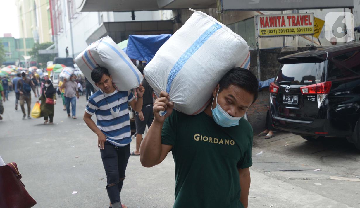 Sejumlah porter saat memanggul pakaian jadi yang di kemas di karung di Kawasan Tanah Abang, Jakarta, Senin (11/10/2021). Menurunnya level PPKM jakarta menjadi level 3 membawa berkah bagi para kuli panggung dikarenakan geliat pasar tersebut kembali berjalan. (Liputan6.com/Angga Yuniar)
