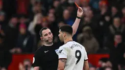 Wasit Chris Kavanagh (kiri) memberikan kartu merah kepada Aleksandar Mitrovic yang melakukan protes berlebihan dalam babak perempat final Piala FA 2022/2023 melawan Manchester United di Old Trafford, Minggu (19/3/2023) malam WIB. (AFP/Paul Ellis)